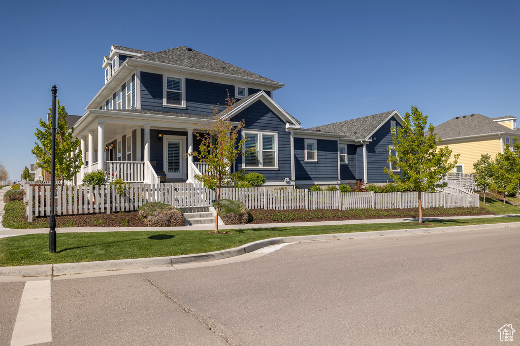 View of front of home featuring covered porch and a fenced front yard
