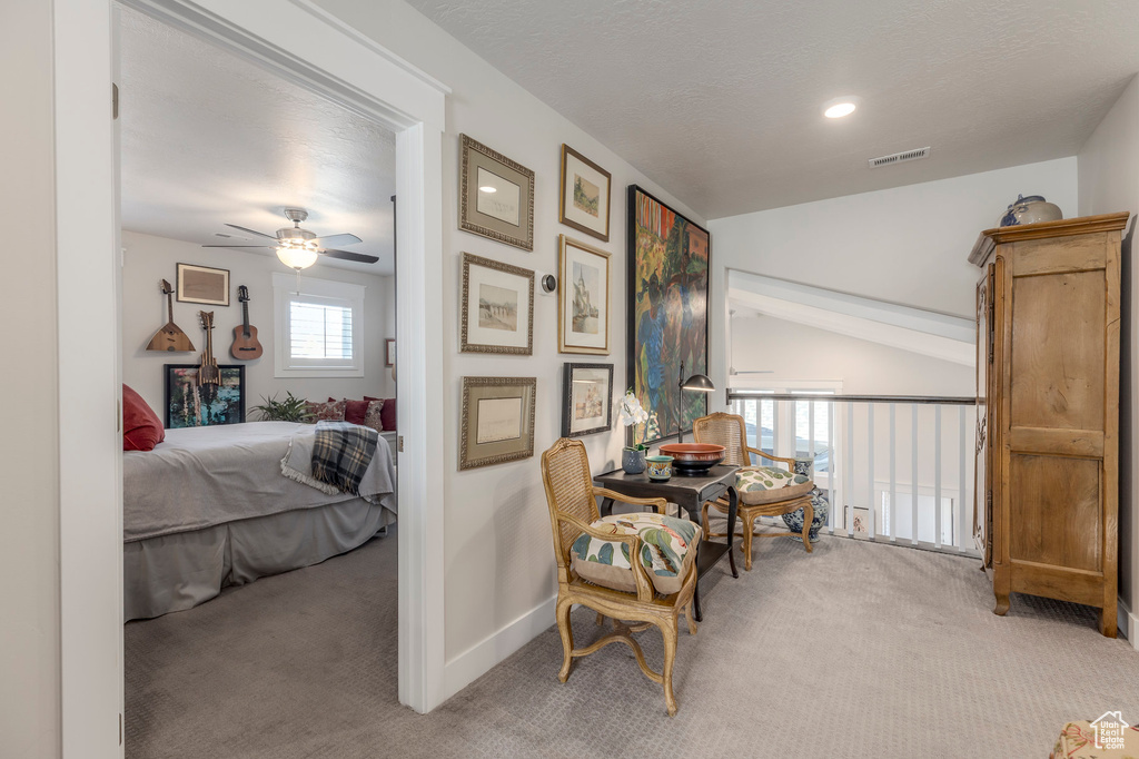 Living area with carpet floors, a ceiling fan, baseboards, and vaulted ceiling