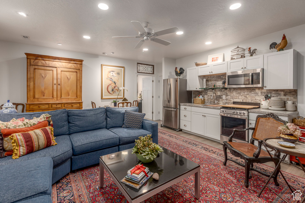 Living area featuring a ceiling fan, recessed lighting, and light wood-style floors