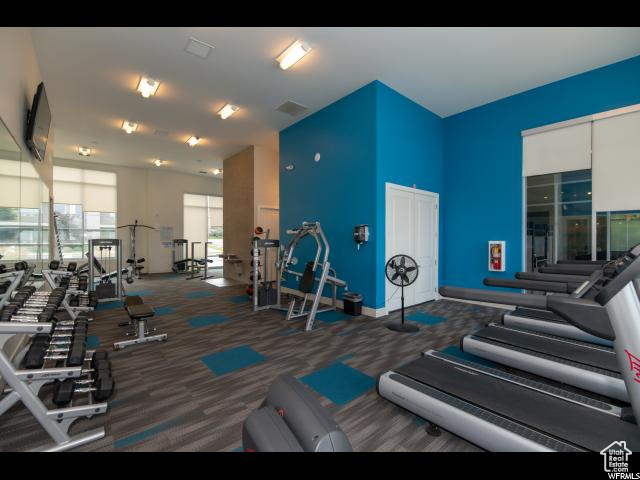 Exercise room featuring carpet flooring and a high ceiling
