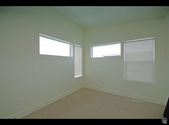 Carpeted empty room with baseboards
