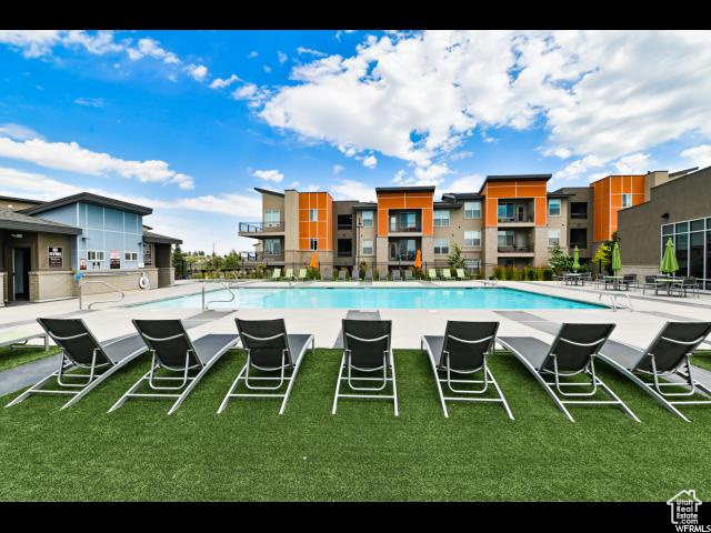 Community pool featuring a patio area and a lawn