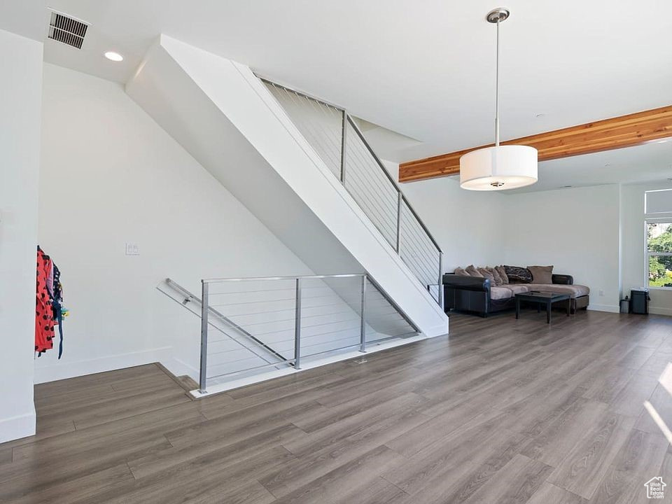 Living area with wood finished floors, baseboards, and recessed lighting