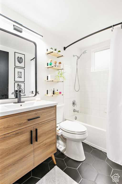 Full bathroom featuring toilet, vanity, tile patterned floors, and shower / bathtub combination with curtain