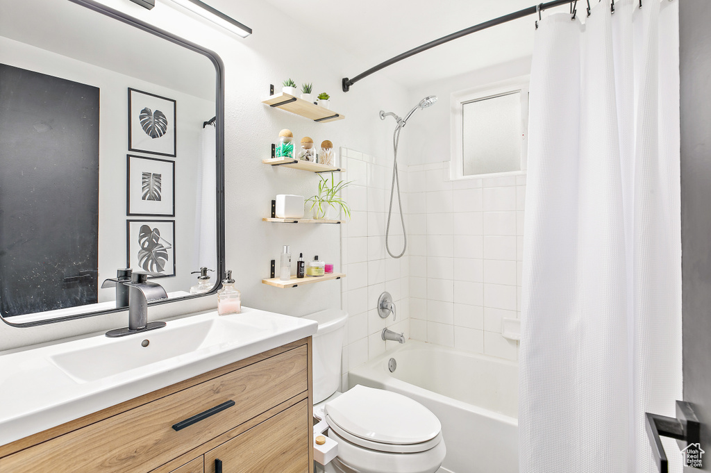 Bathroom with toilet, shower / bath combo, and vanity