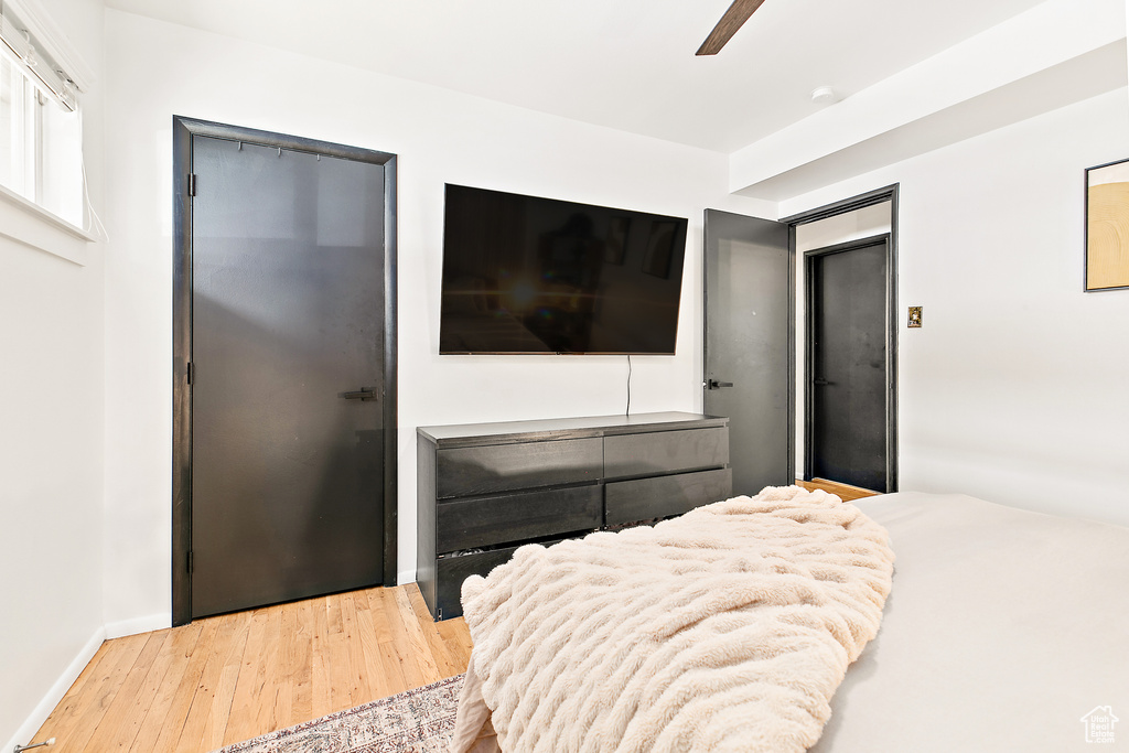 Bedroom featuring hardwood / wood-style flooring, a ceiling fan, and baseboards
