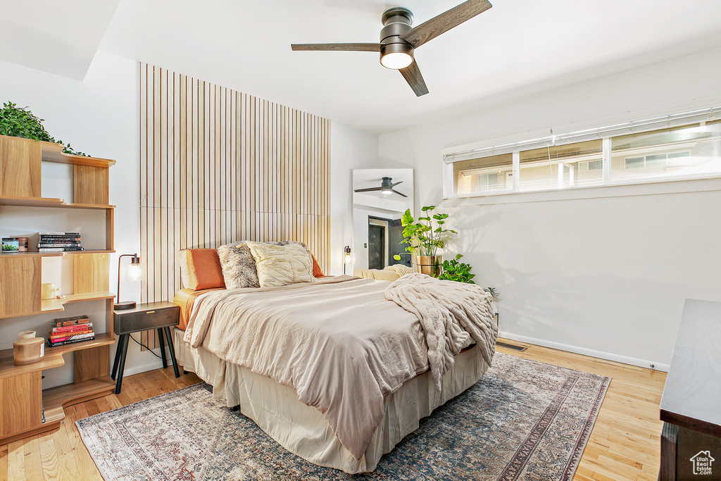 Bedroom featuring light wood-style floors, baseboards, and a ceiling fan