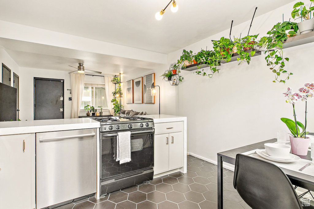 Kitchen featuring gas range oven, dishwasher, white cabinets, and light countertops