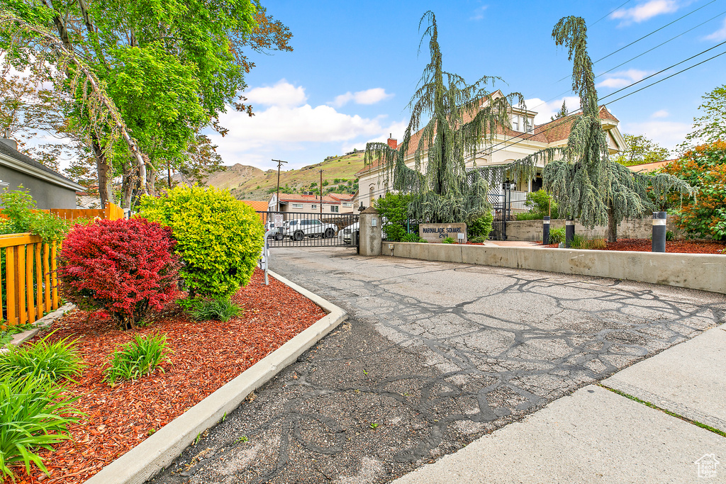 View of asphalt street with a gate and a gated entry