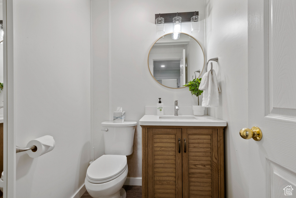 Bathroom with vanity, baseboards, and toilet