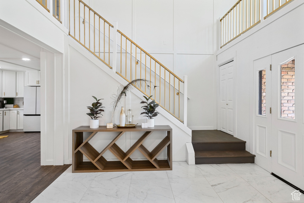 Foyer featuring a high ceiling, stairs, and marble finish floor
