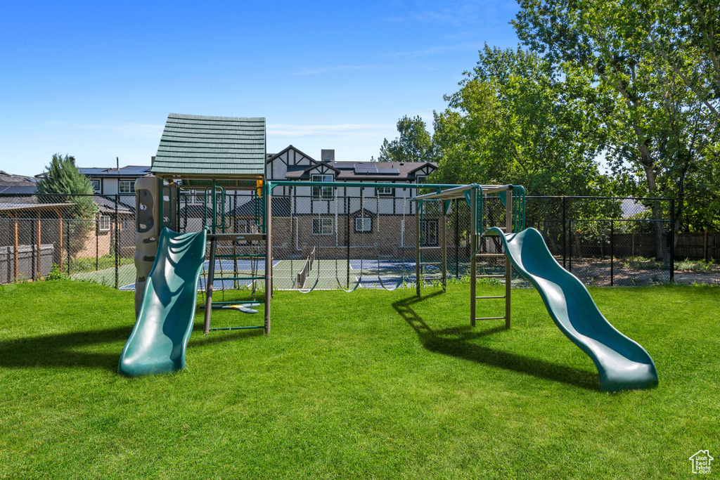 Communal playground with fence and a lawn