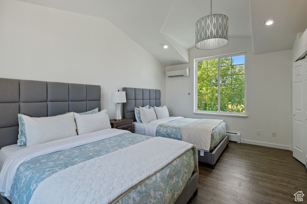Bedroom with baseboard heating, a wall unit AC, vaulted ceiling, and dark wood-style floors