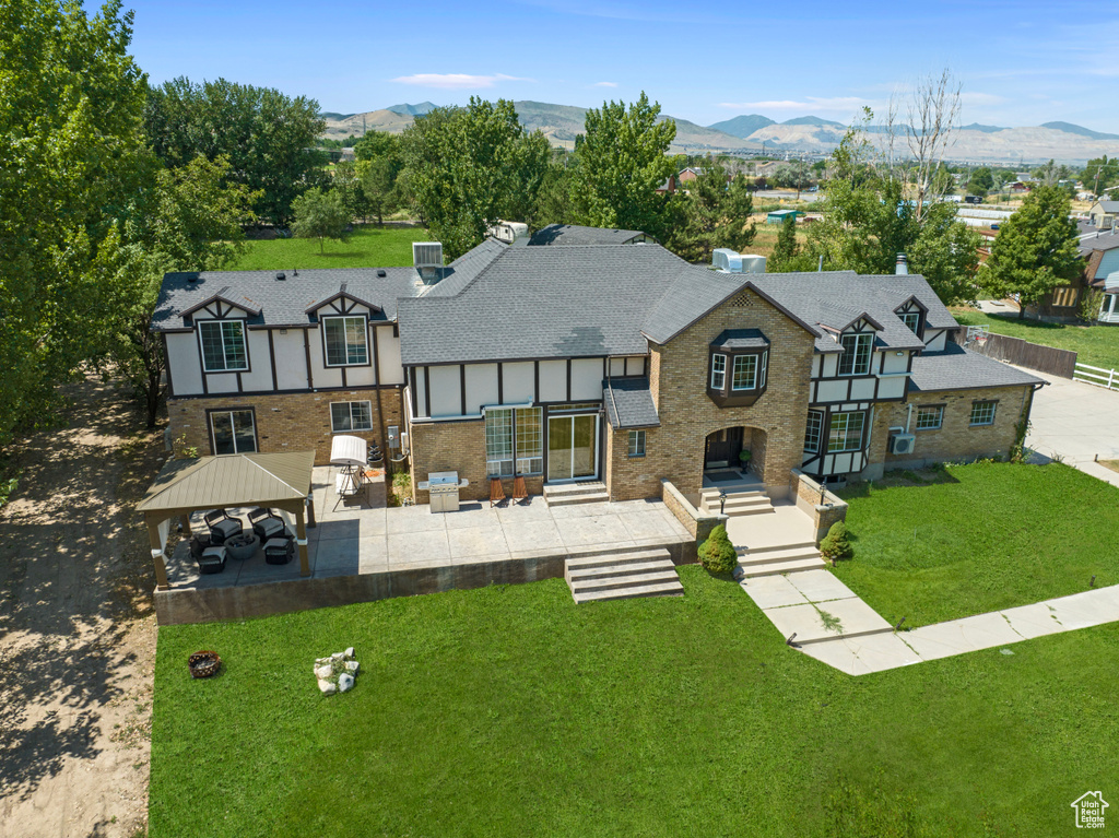 View of front of property featuring a mountain view, a gazebo, a patio, and a front yard