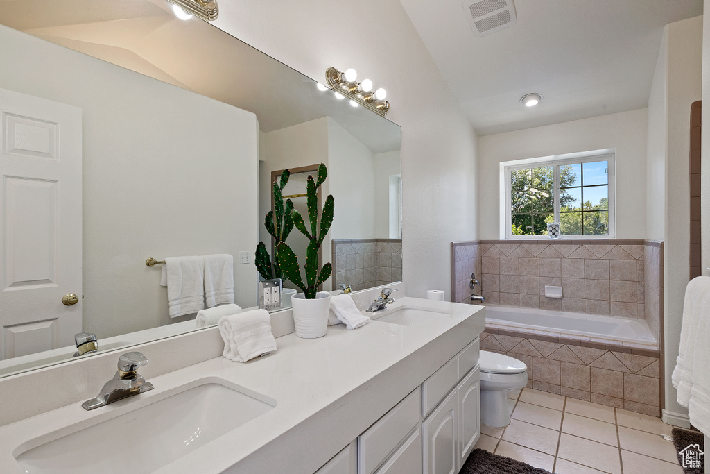 Bathroom featuring a sink, tile patterned flooring, tiled tub, and visible vents