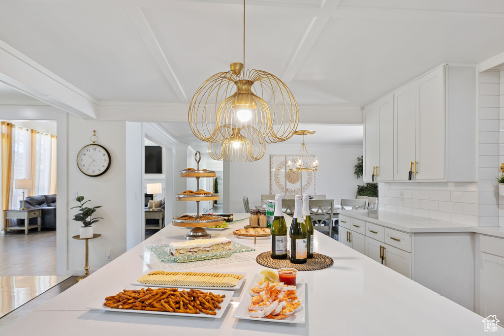 Dining area with a chandelier and beamed ceiling