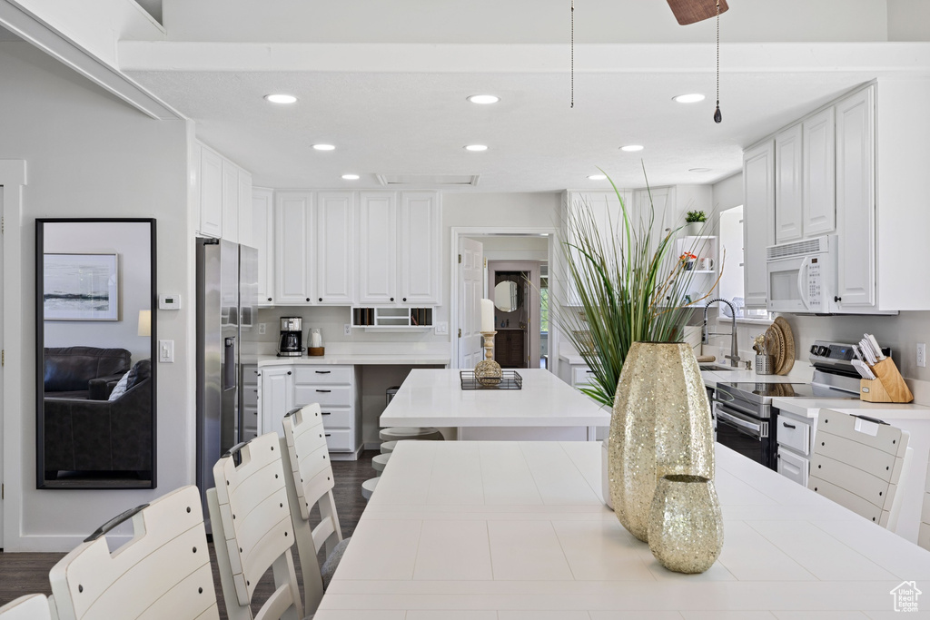 Kitchen featuring appliances with stainless steel finishes, recessed lighting, white cabinets, and light countertops