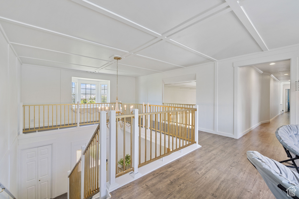 Hall with an upstairs landing, wood finished floors, and baseboards