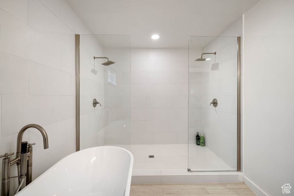 Full bath featuring a walk in shower, a freestanding bath, and recessed lighting