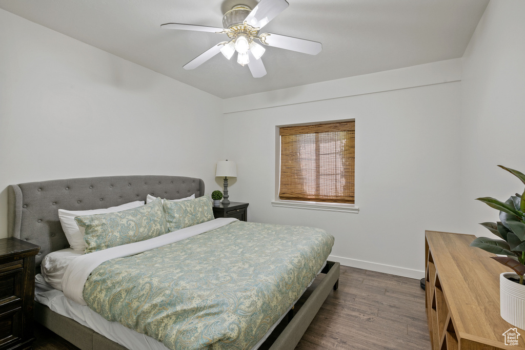 Bedroom with baseboards, ceiling fan, and dark wood-type flooring