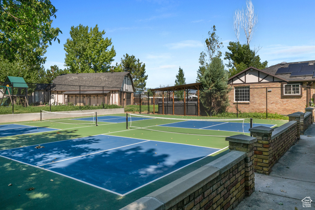 View of tennis court with fence and community basketball court