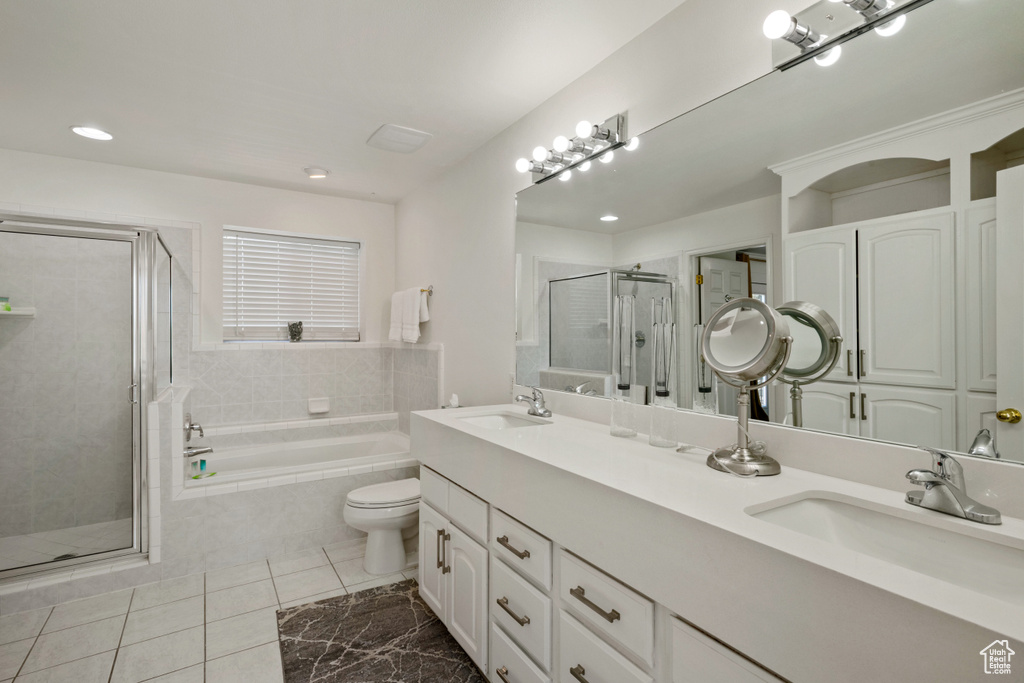 Full bathroom featuring a sink, double vanity, a stall shower, and a garden tub
