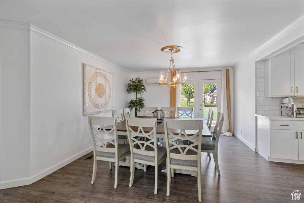 Dining area featuring baseboards, ornamental molding, and dark wood finished floors