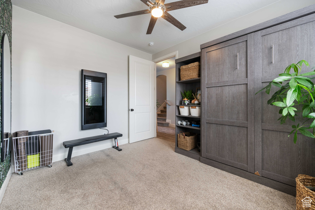 Carpeted bedroom featuring arched walkways, baseboards, and ceiling fan