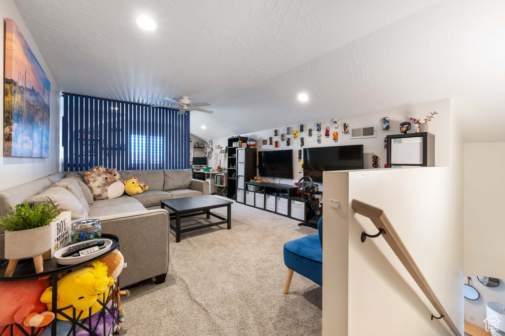 Living area featuring vaulted ceiling, carpet, a ceiling fan, and recessed lighting