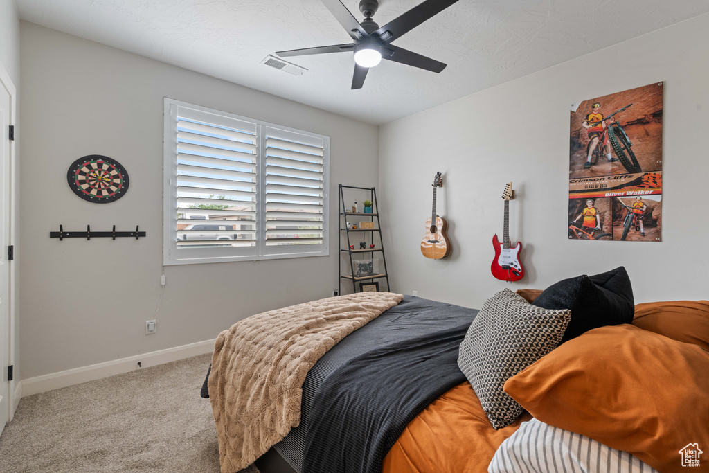 Carpeted bedroom with baseboards and a ceiling fan