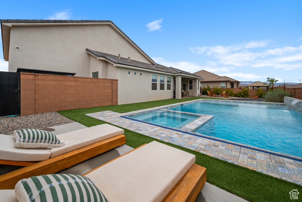 View of swimming pool featuring an in-ground hot tub and fence