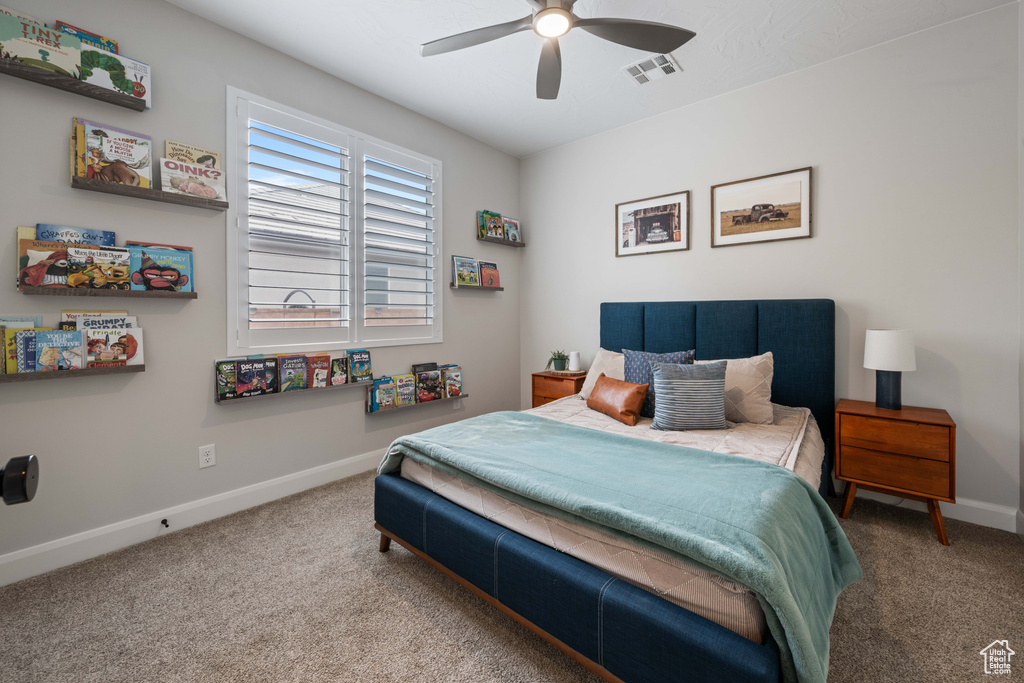 Carpeted bedroom featuring baseboards and ceiling fan