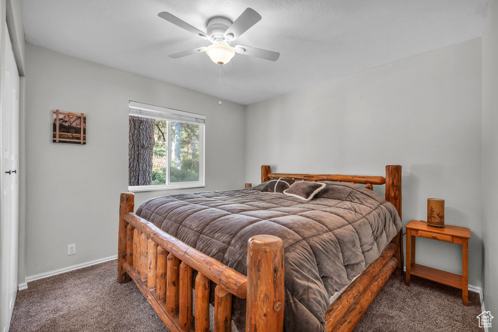 Carpeted bedroom with baseboards and ceiling fan
