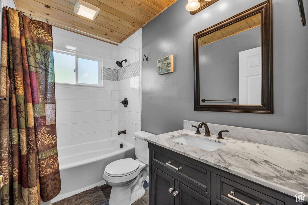 Full bathroom featuring wooden ceiling, shower / bath combo with shower curtain, toilet, and vanity