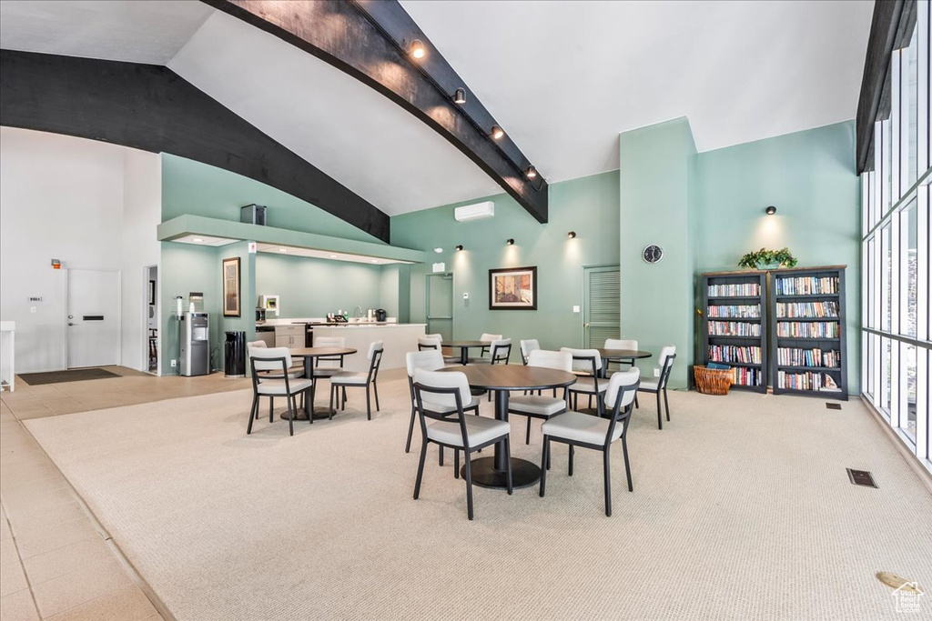 Dining area with high vaulted ceiling, carpet flooring, and beam ceiling