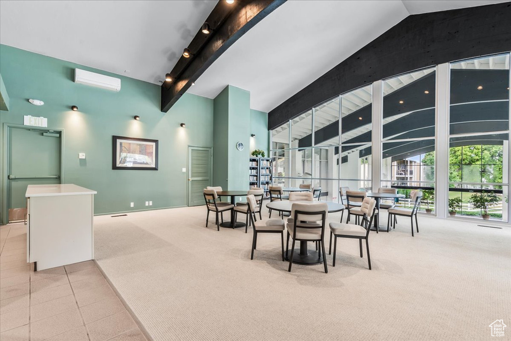 Dining area featuring beam ceiling, light carpet, and high vaulted ceiling