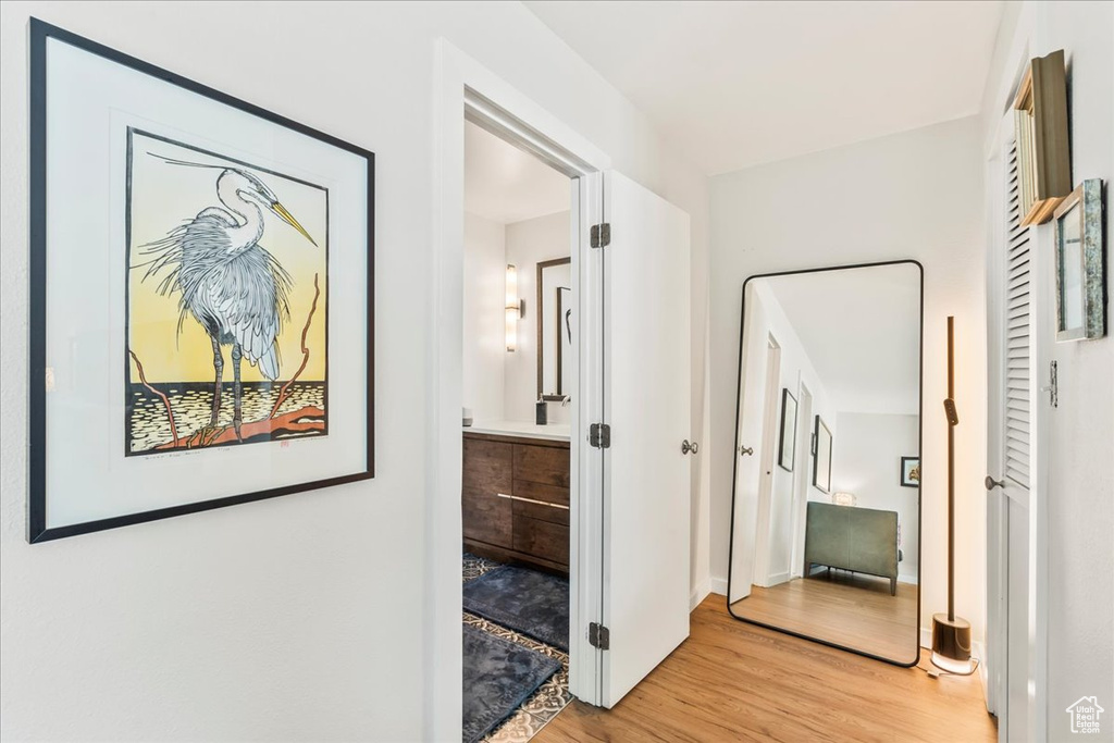 Hallway with light wood-type flooring and baseboards