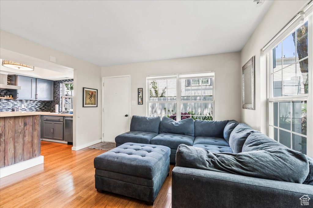 Living room with plenty of natural light, light wood-style flooring, and baseboards