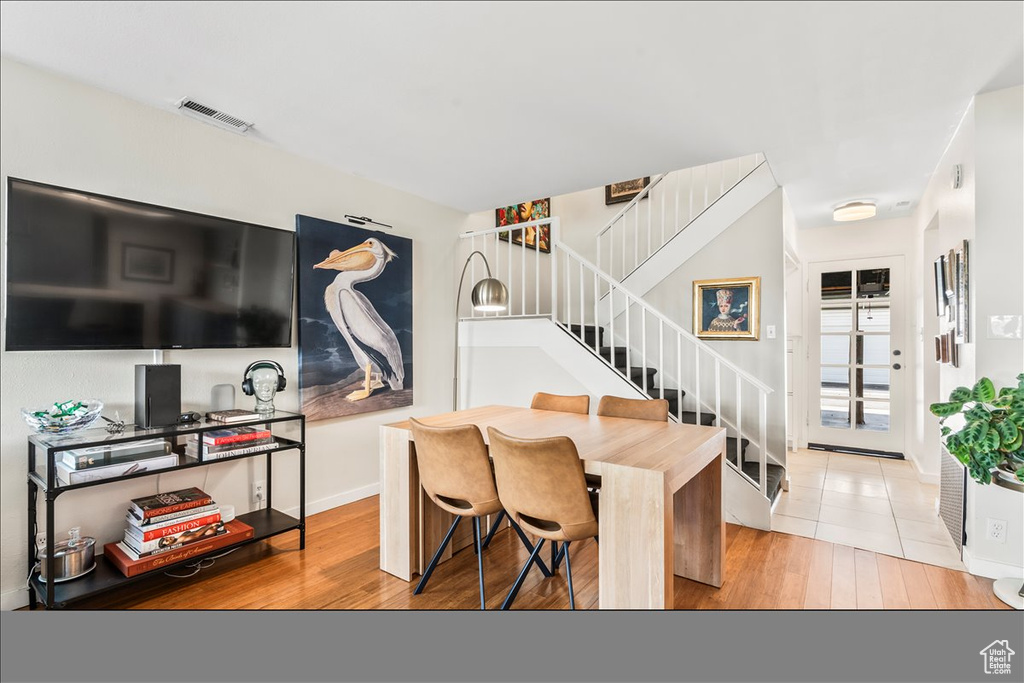 Dining room with stairway and wood finished floors