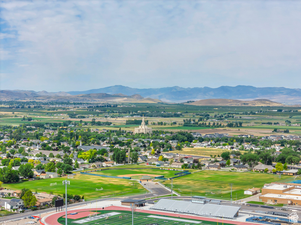 Aerial view of property and surrounding area featuring a mountainous background and property boundaries highlighted