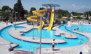 View of swimming pool with a water slide, a water play area, and a jacuzzi