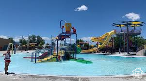 Community jungle gym featuring a water play area and a community pool