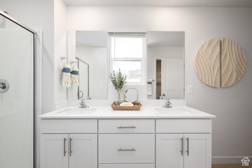 Bathroom featuring a stall shower and double vanity