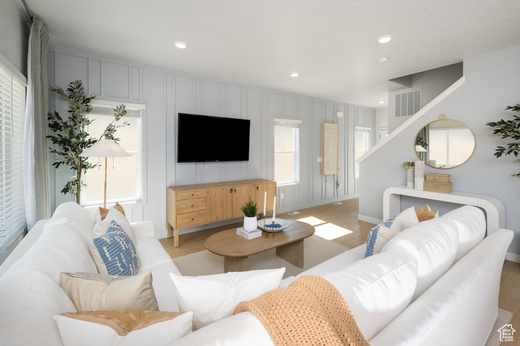 Living area featuring light wood-type flooring, baseboards, and recessed lighting