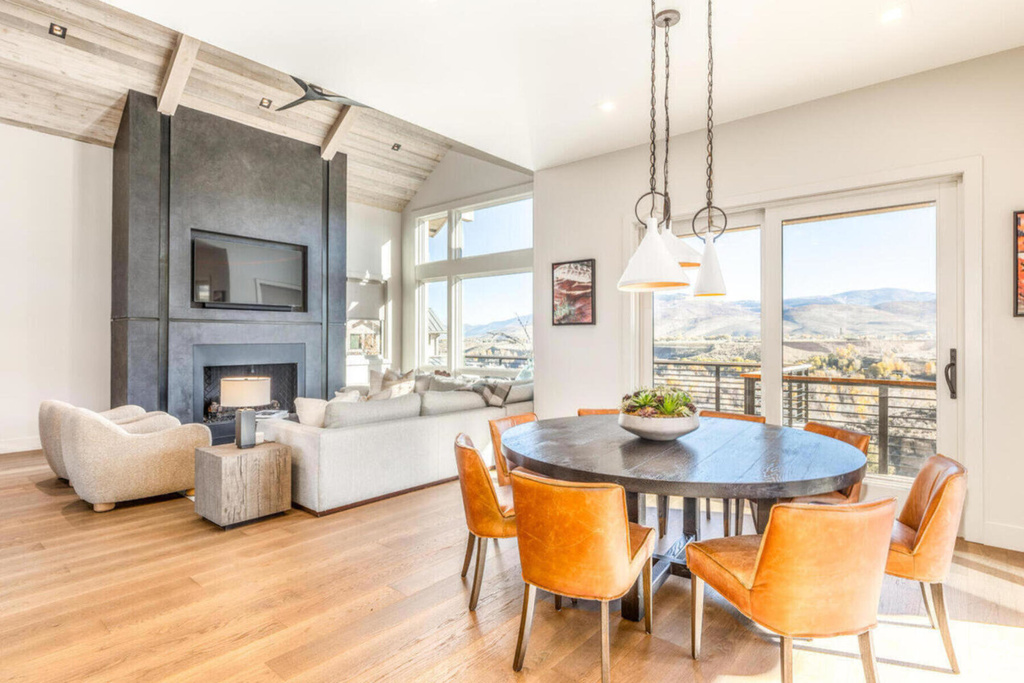 Dining space featuring light wood-style flooring, a fireplace, and lofted ceiling