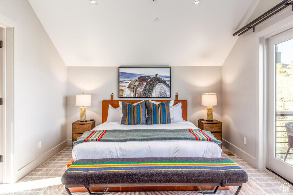 Carpeted bedroom featuring vaulted ceiling, baseboards, and access to outside