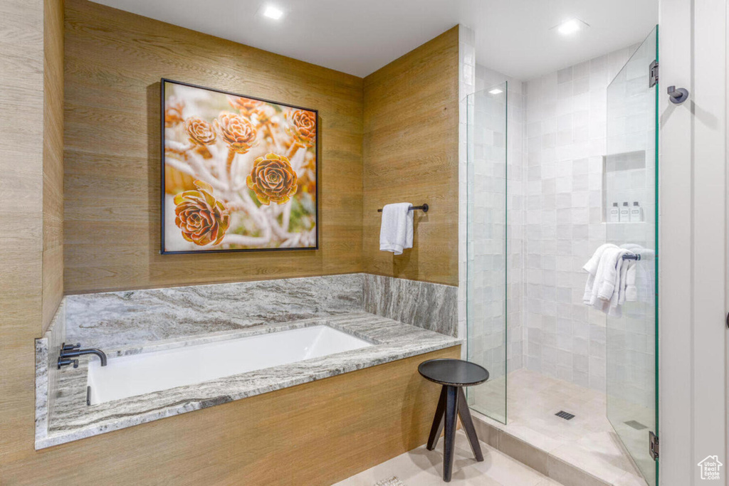 Bathroom featuring a stall shower, a garden tub, and recessed lighting