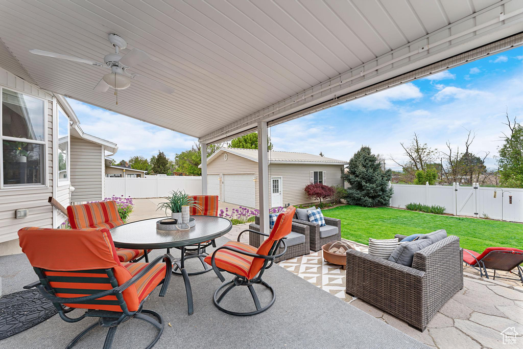 View of patio / terrace featuring an outdoor living space, outdoor dining area, an outbuilding, and a ceiling fan