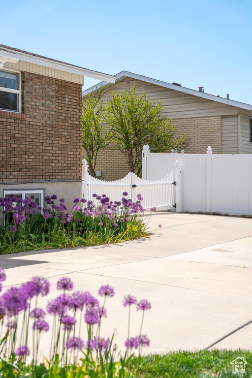 View of property exterior featuring brick siding, fence, and a gate