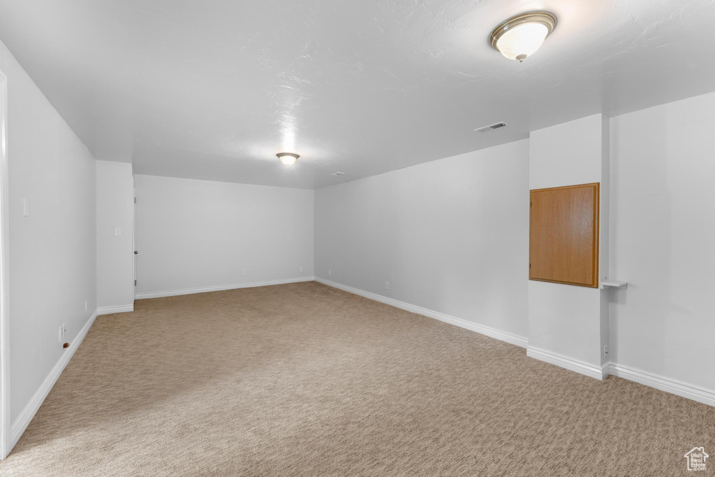 Spare room featuring light carpet and baseboards